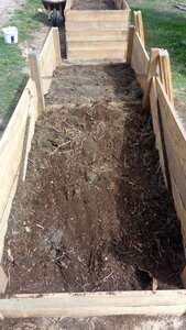 Lavernois vivrier 01 : mes premiers bacs potagers, Retour aux bacs : je verse donc le contenu de la brouette, puis déporte vers le centre. J’en profite pour enlever les cailloux, car je me suis rendu compte que ce n’était pas tellement de la terre, mais un mélange, abondant en cailloux plus ou moins gros, entre autres… Sur cette photo, l’œil averti peut distinguer une erreur de débutant…