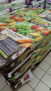 Lavernois vivrier 01 : mes premiers bacs potagers, 7€26 les 40L de terreau potager en grande surface généraliste. Il y a sûrement moins cher, mais juste pour le calcul : un bac contient environ 2250L, il me faudrait 56 sacs pour le remplir (3 palettes, sic), ce qui me coûterait la bagatelle de 408€. Donc, même si trouver ou produire de la bonne terre en récupérant et déplaçant l’existant est fastidieux, je peux me dire qu’à terme, j’aurai produit cette valeur en terre…