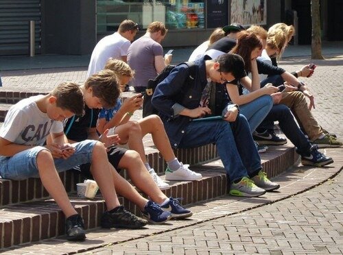 Photo d'un groupe de jeunes absorbés par leurs smartphones