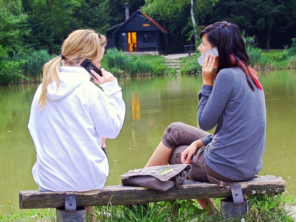 Photo de deux jeunes filles se téléphonant